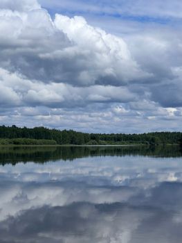 Serene landscape of a lake reflecting cloudy skies in Mulym'ya, Russia.