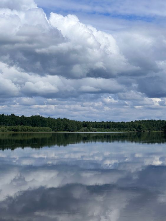 A lake with clouds and water reflecting the sky · Free Stock Photo