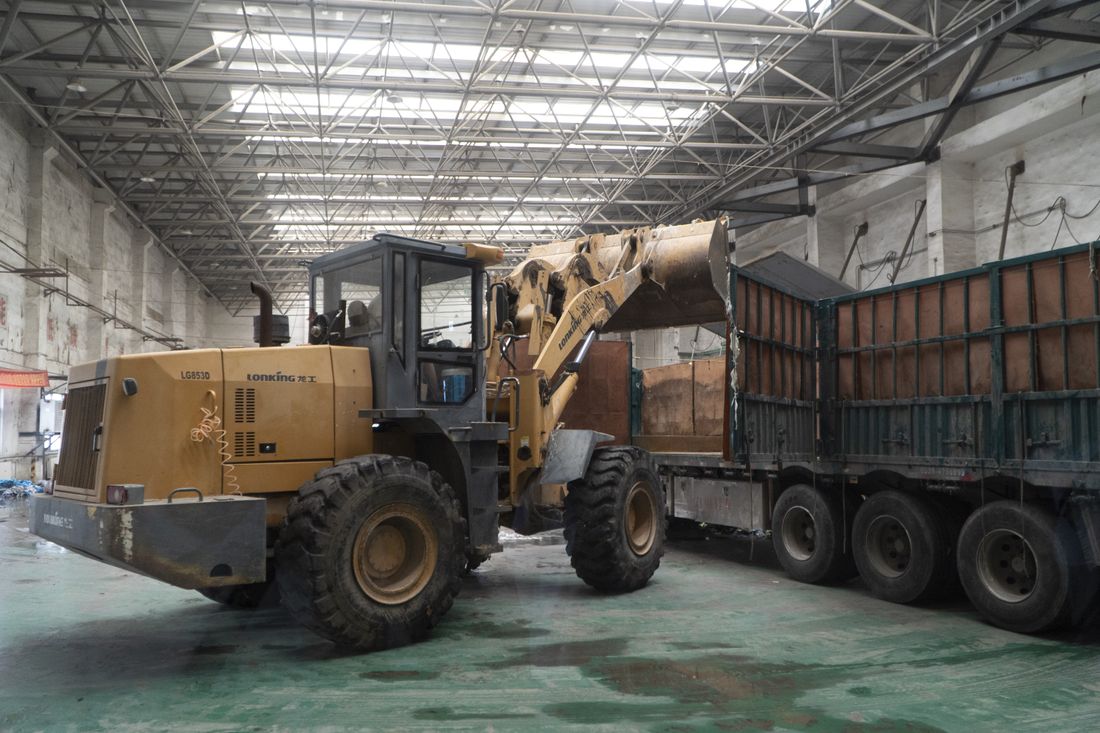 Heavy-duty loader transferring materials in a workshop