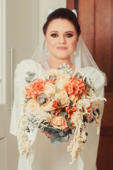 Bride presenting a vibrant floral bouquet, symbolizing elegance and romance in a wedding setting.