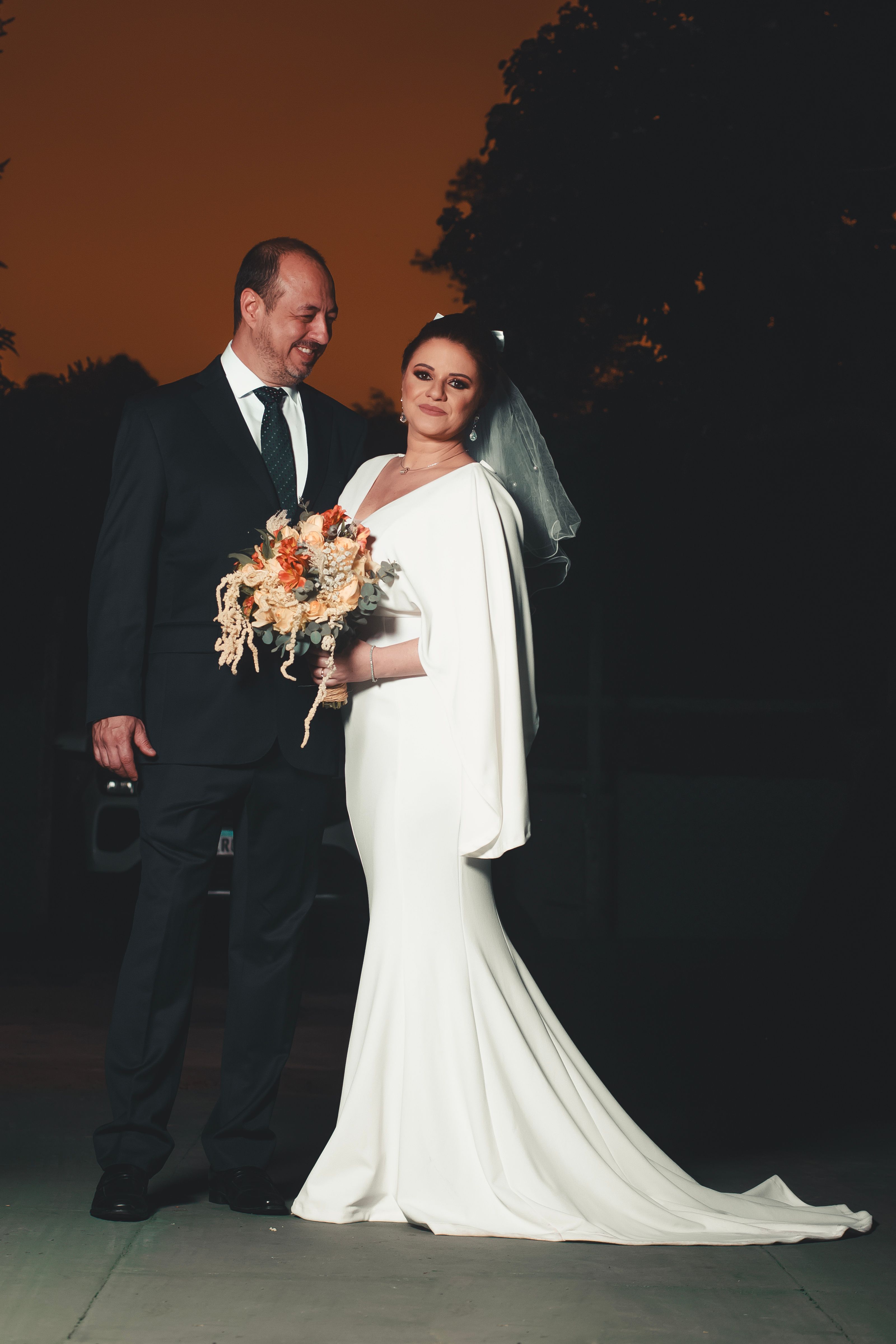 Beautiful wedding portrait of a bride and groom at sunset, embracing love and elegance.