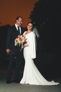 Beautiful wedding portrait of a bride and groom at sunset, embracing love and elegance.