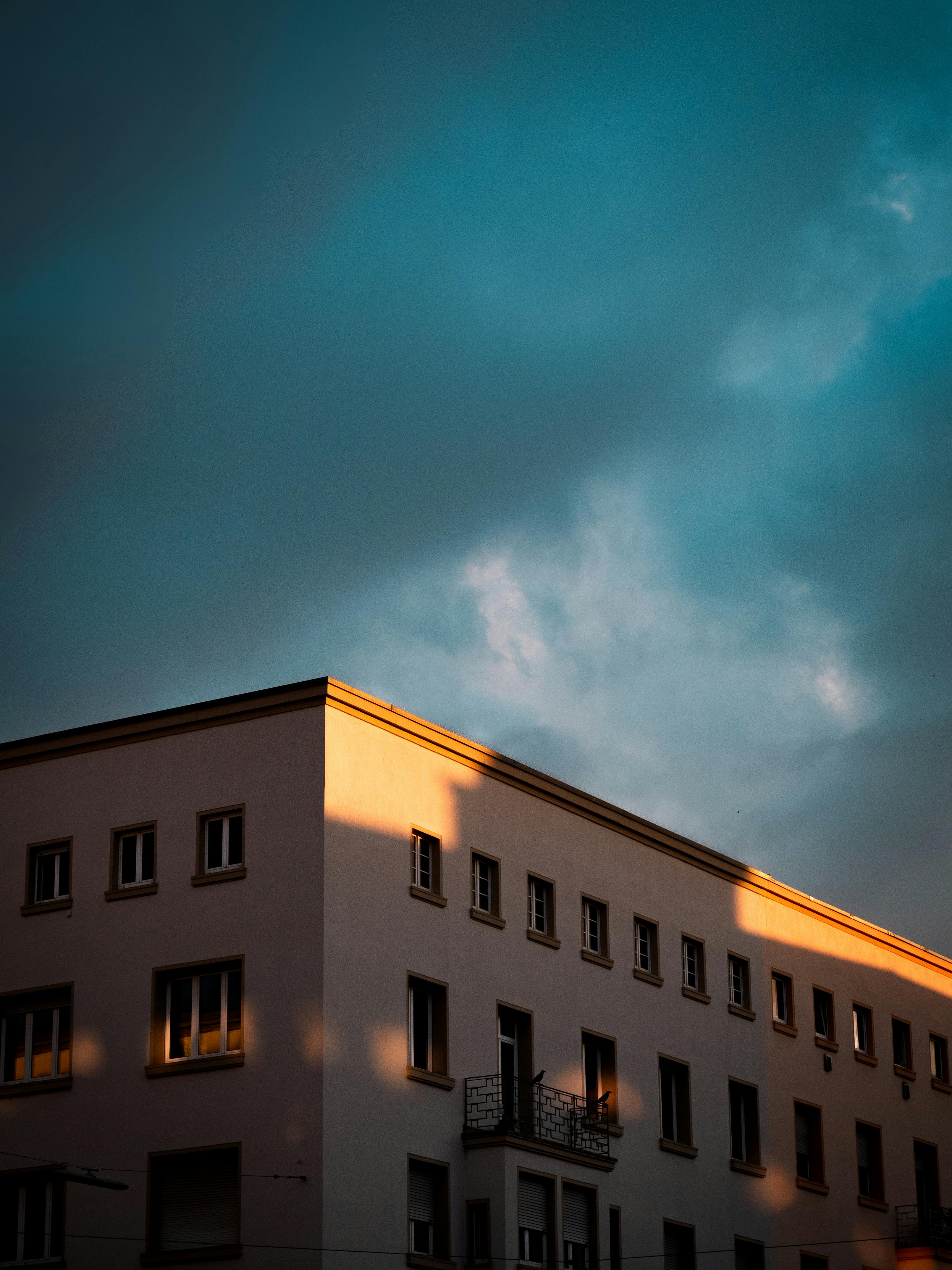 Sunset light casts shadows on an urban building in Karlsruhe, evoking a sense of mystery.