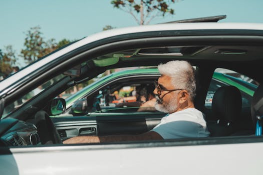 Senior man driving a vintage sports car on a sunny day in İstanbul, Türkiye.