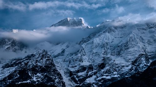 Free Stunning view of a snow-covered mountain peak surrounded by clouds, perfect for winter landscapes. Stock Photo
