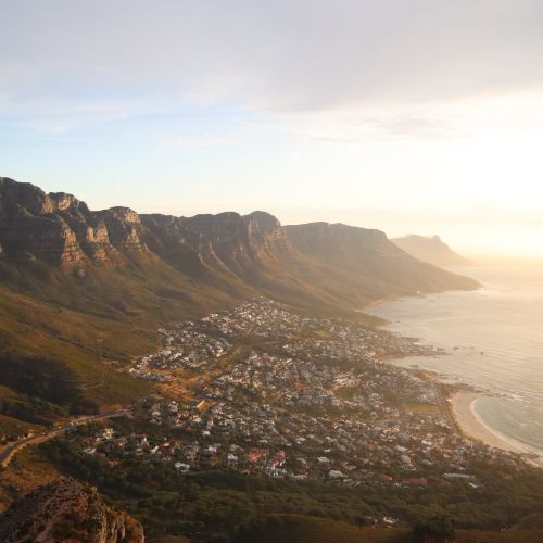 Free A stunning aerial view of Cape Town's coastline with mountains and sea at sunset. Stock Photo
