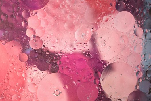 Abstract oil and water bubbles with vibrant pink and purple hues creating a dreamy effect.