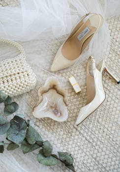 A sophisticated flat lay of bridal accessories including high heels, a pearl bag, and elegant jewelry.