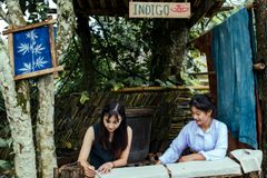 Two women engaging in indigo dyeing at a rustic outdoor setting, showcasing traditional craftsmanship.