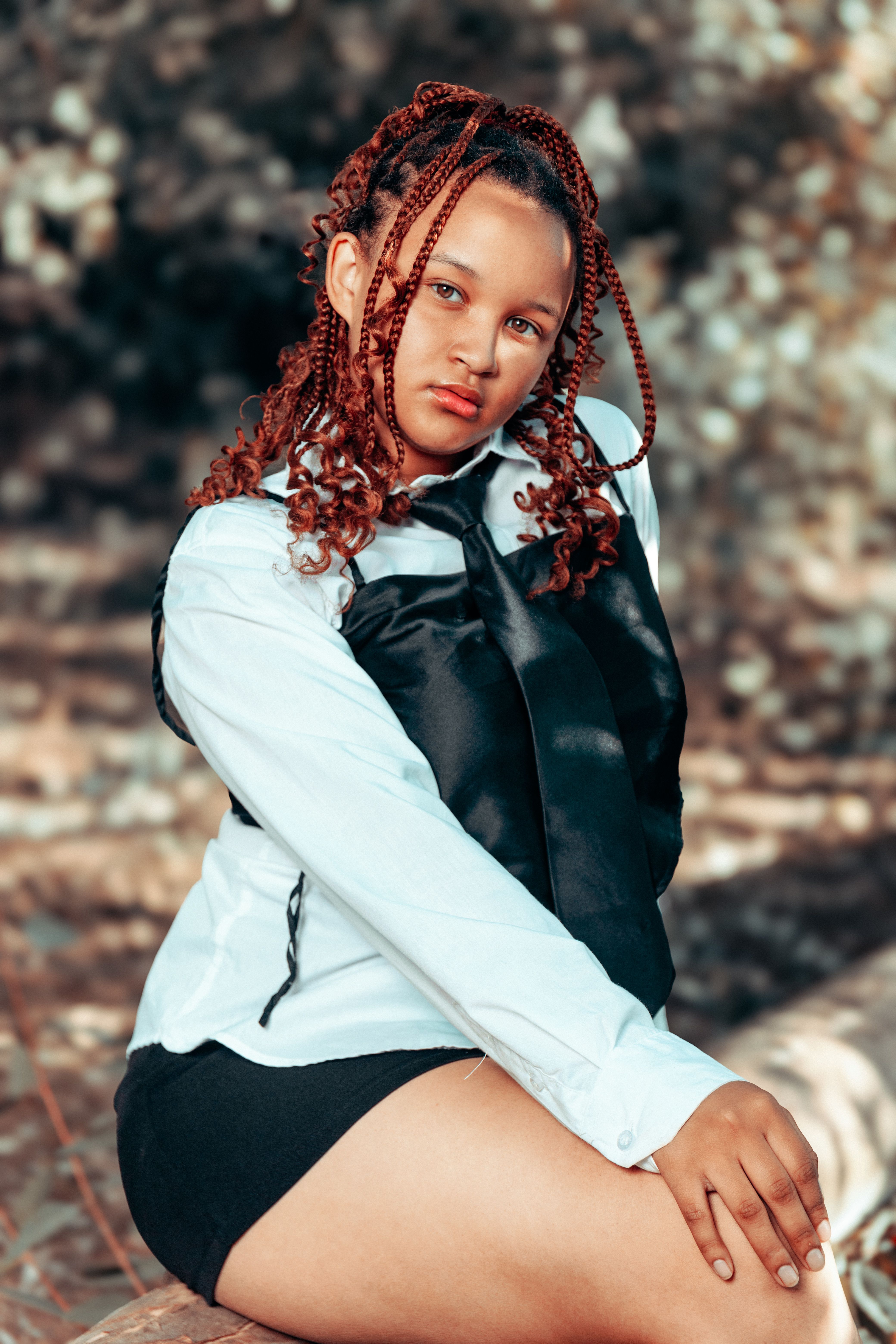 A young woman with red hair sitting on a log · Free Stock Photo
