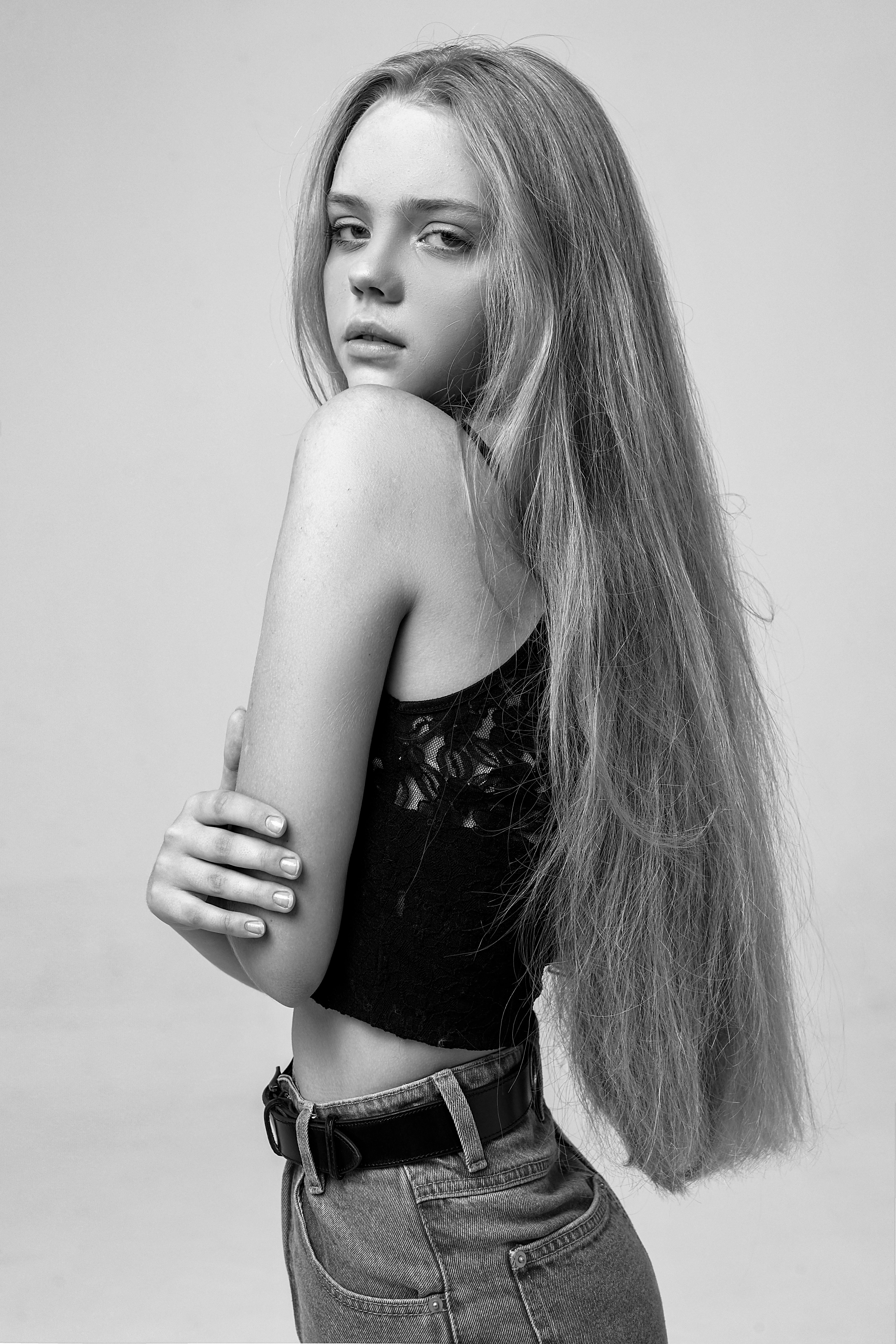 Stylish black and white portrait of a young woman with long hair, capturing elegance.
