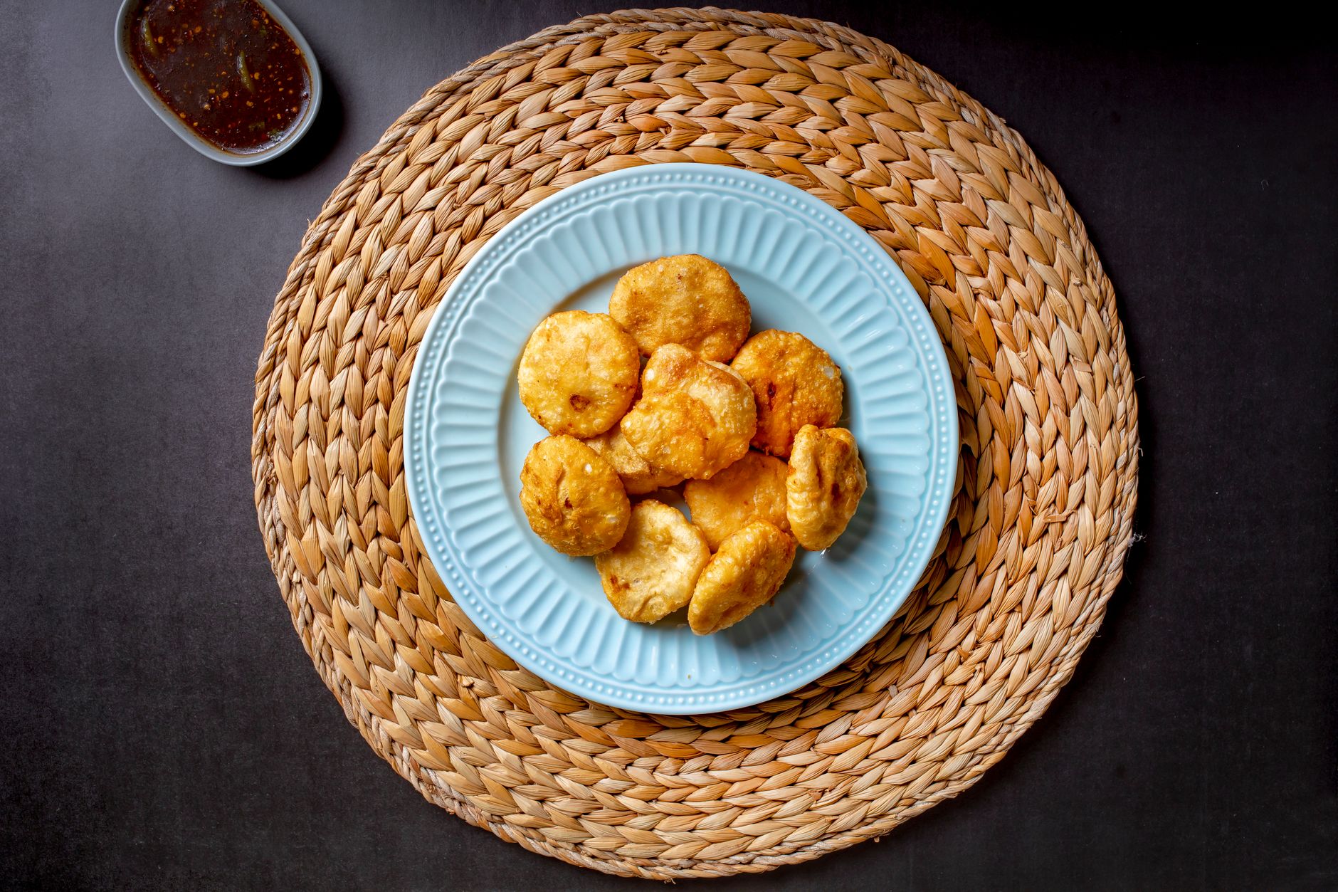 Crispy homemade puri served on a blue plate, accompanied by flavorful sauce.