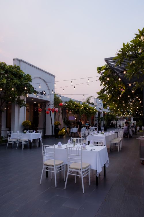 Free Charming outdoor cafe adorned with string lights, offering a cozy dining experience. Stock Photo
