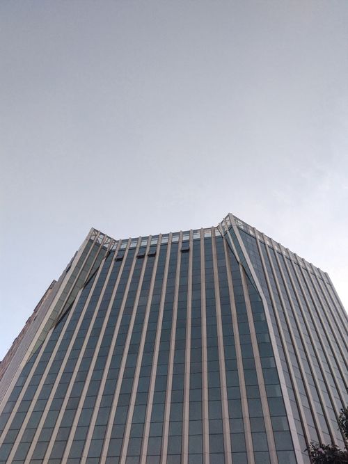 Free A striking modern high-rise building with a glass facade, showcasing contemporary architecture. Stock Photo
