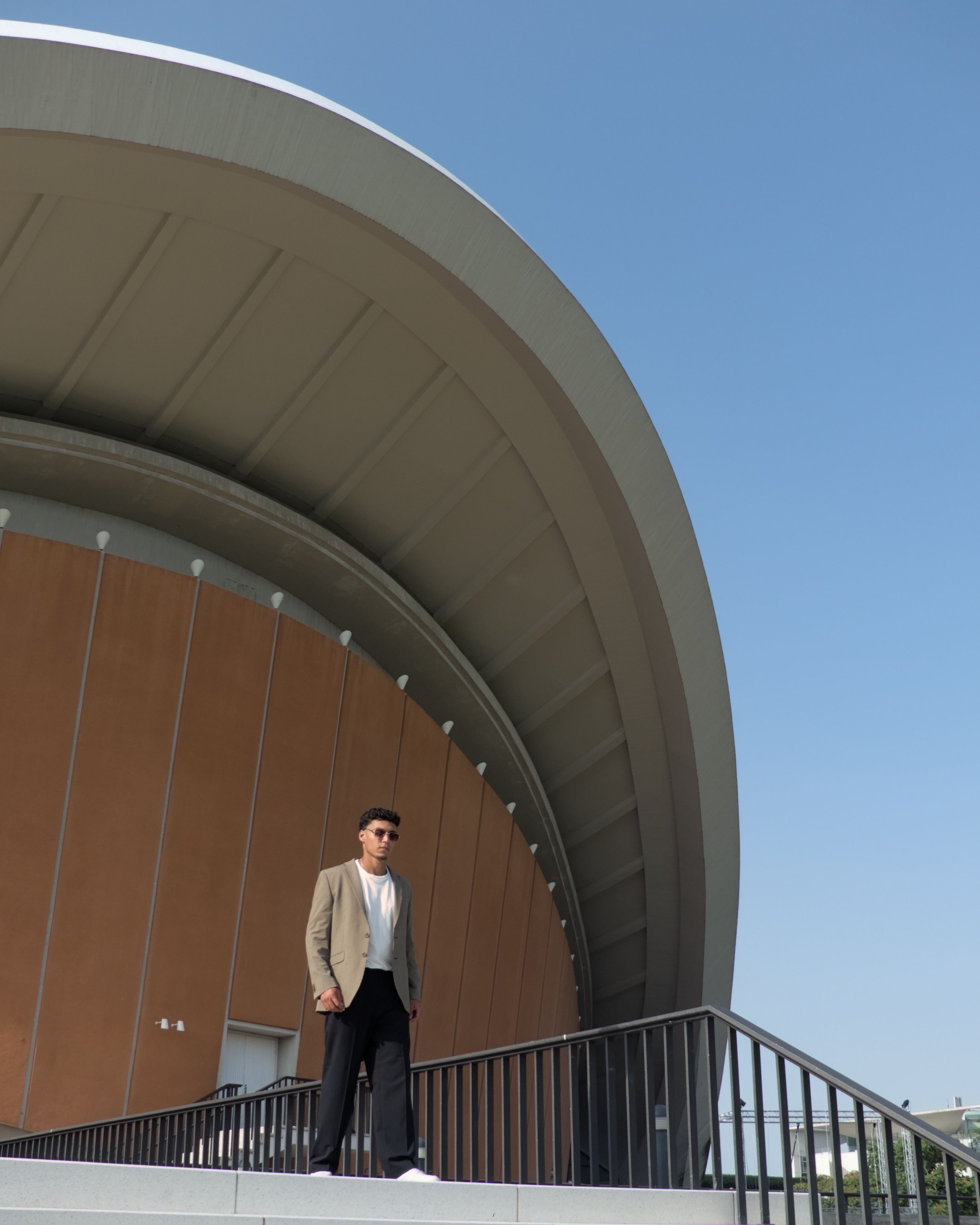 Man standing by the Berlin Congress Hall, showcasing modern architecture.