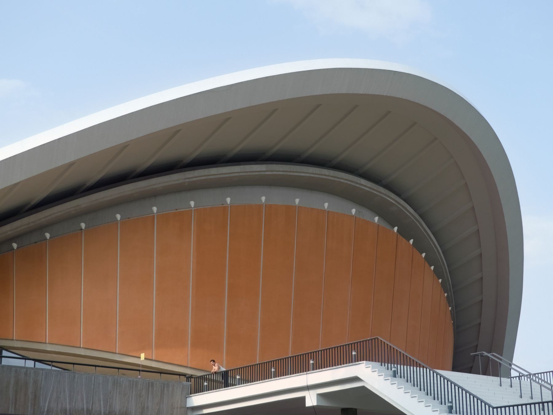 Sweeping curved roof of a modern performance venue in daylight