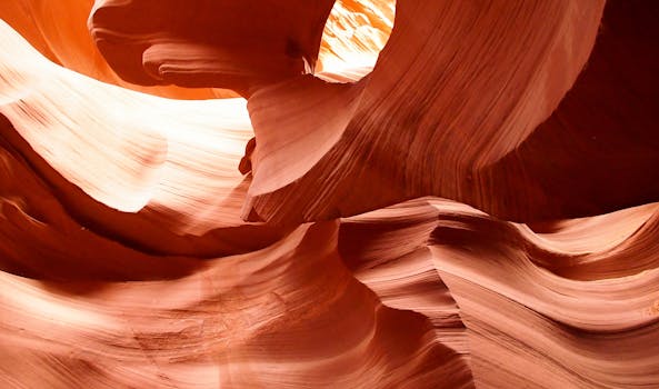 在明亮的日光下，探索亚利桑那州羚羊峡谷令人惊叹的红色砂岩地层并拍摄