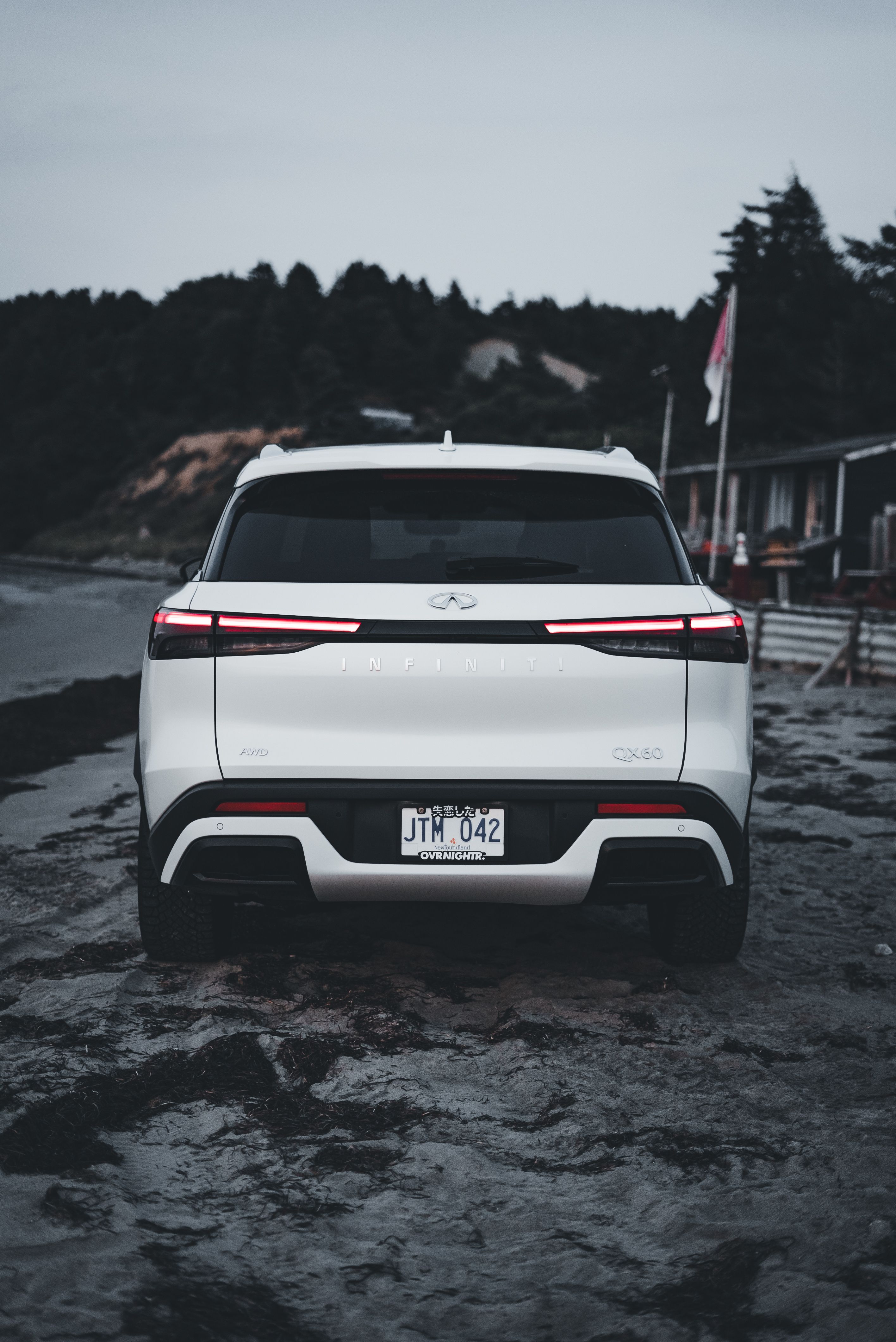 The rear end of a white suv parked on the beach · Free Stock Photo