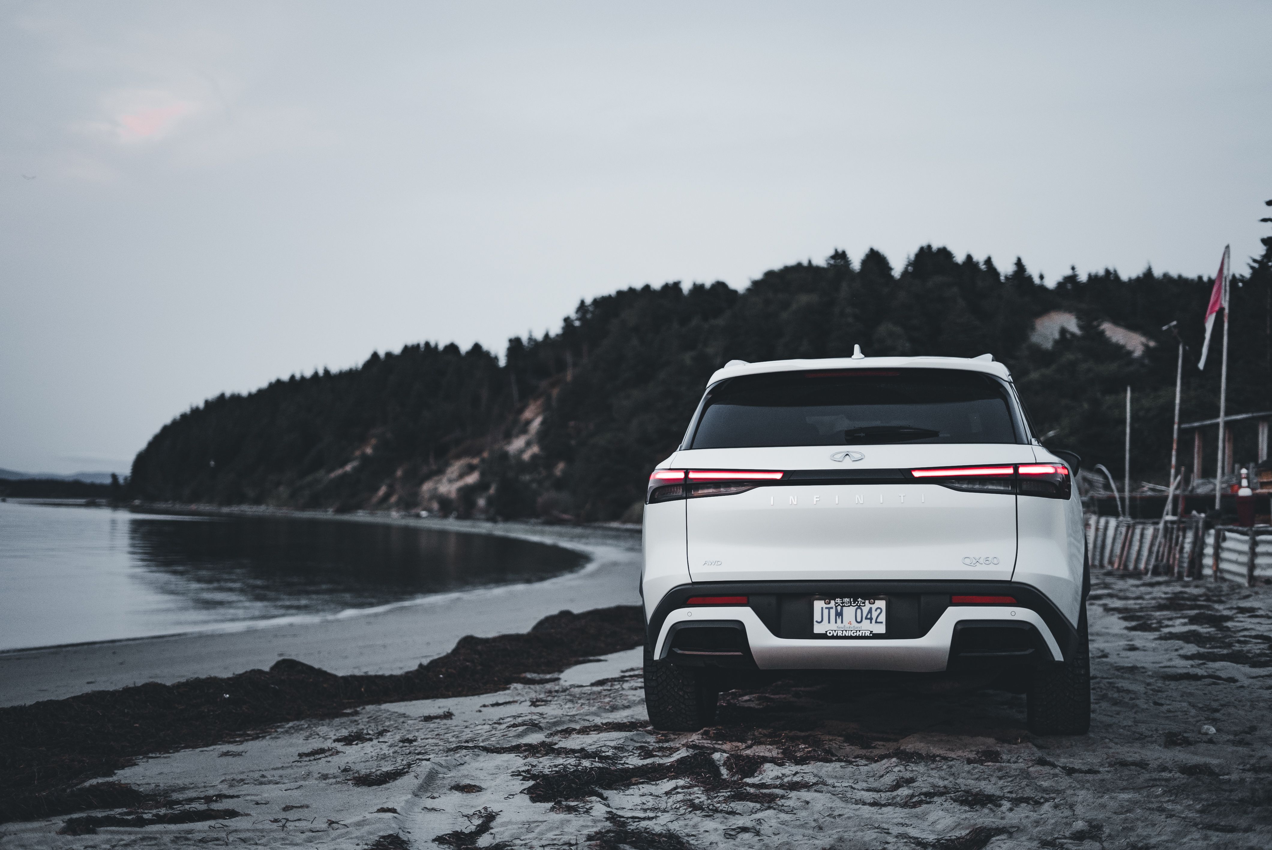 The rear end of a white suv parked on the beach · Free Stock Photo