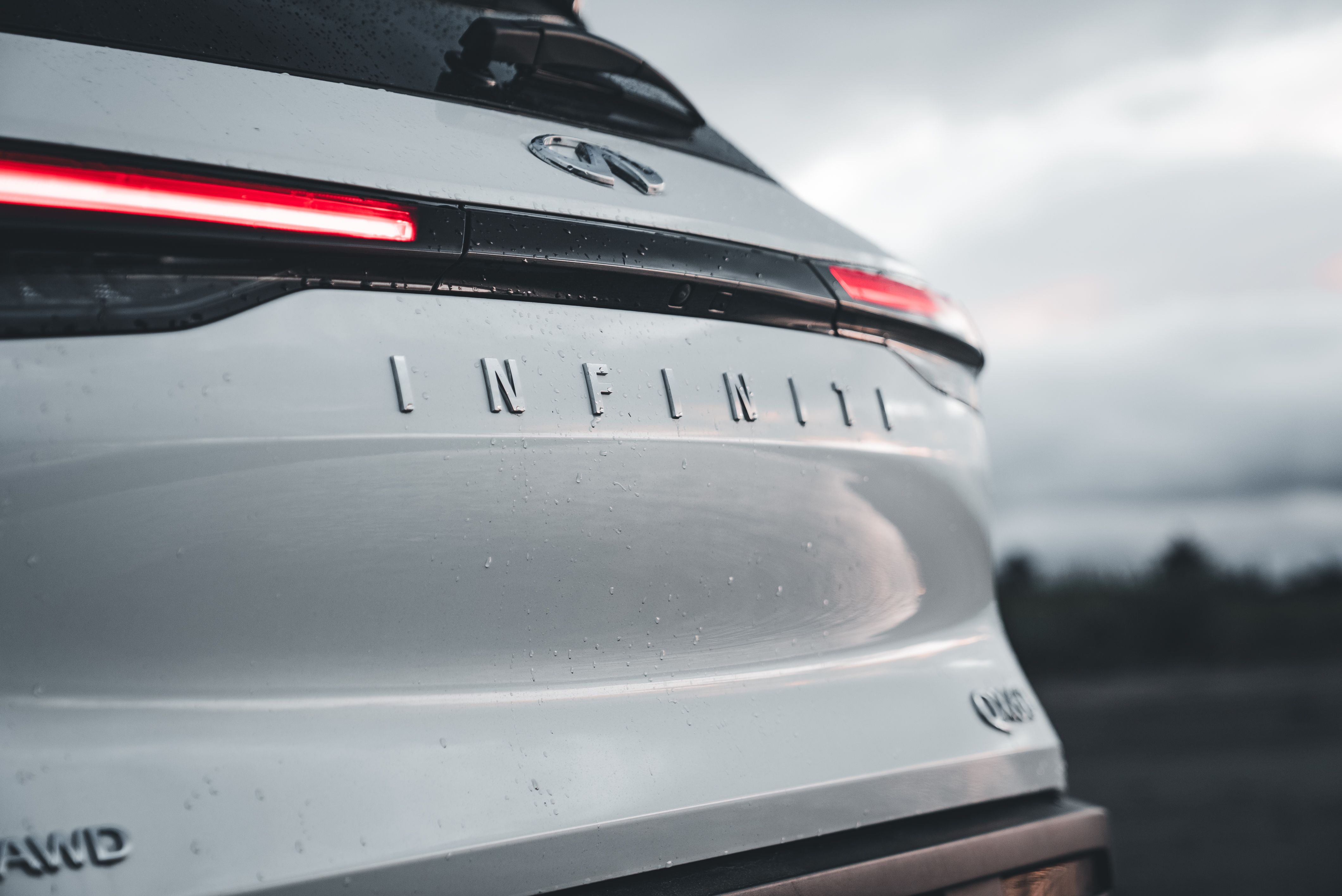 The rear end of a white car with the word infinity on it · Free Stock Photo