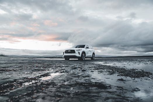 A white SUV parked on wet sand under a dramatic cloudy sky, ideal for adventure themes.