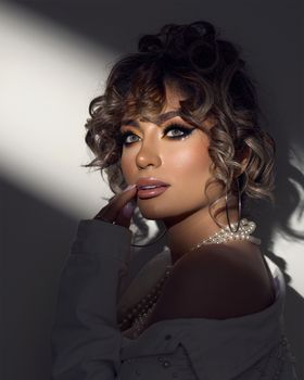 Intriguing portrait of a woman with artistic makeup and elegant jewelry, captivating in style.