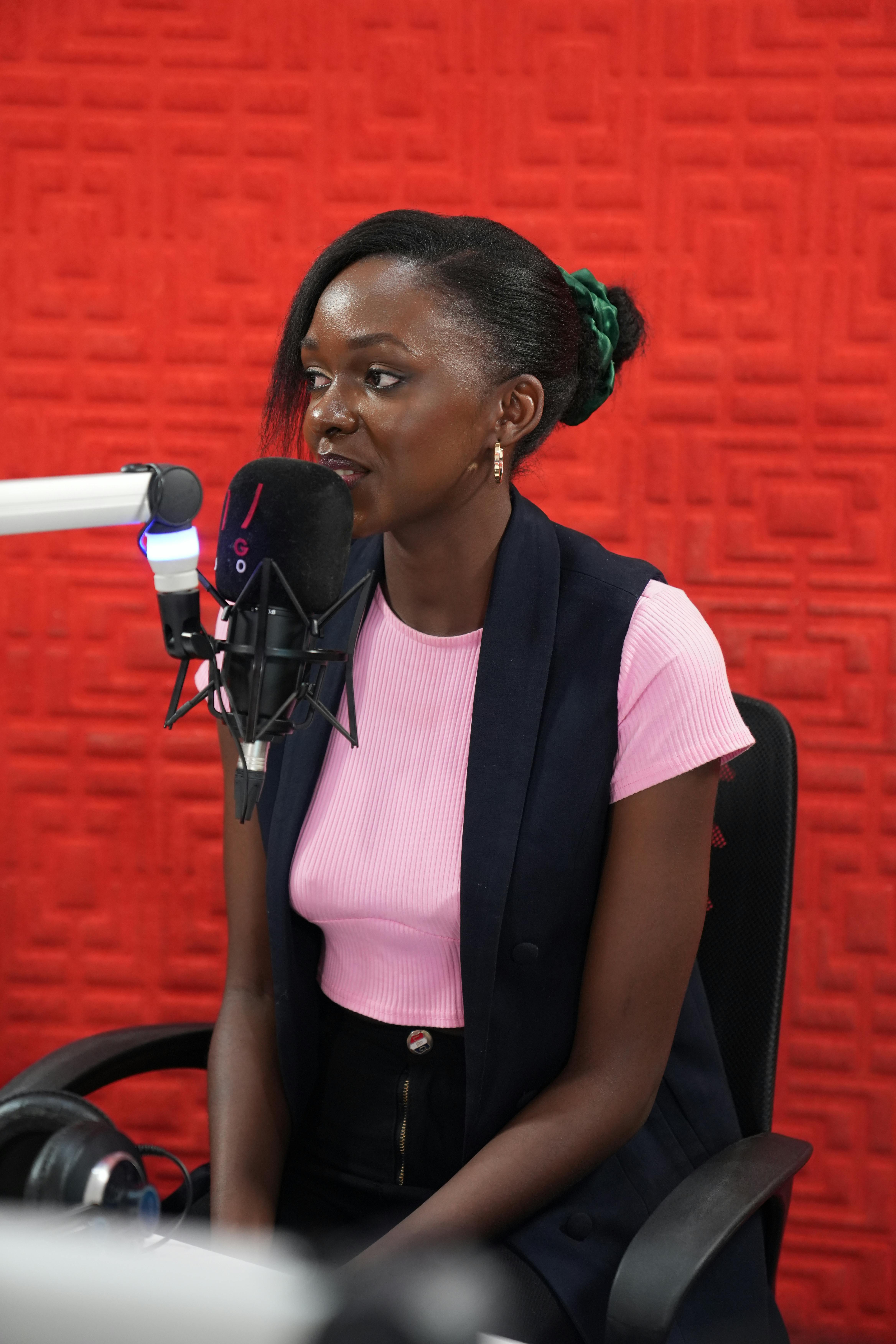 a woman sitting in front of a microphone