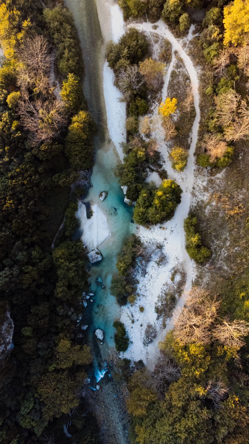 Free Breathtaking aerial shot capturing a forest landscape with a meandering river in autumn colors. Stock Photo