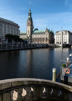 Beautiful view of Hamburg Town Hall reflecting in the canal under a clear blue sky.