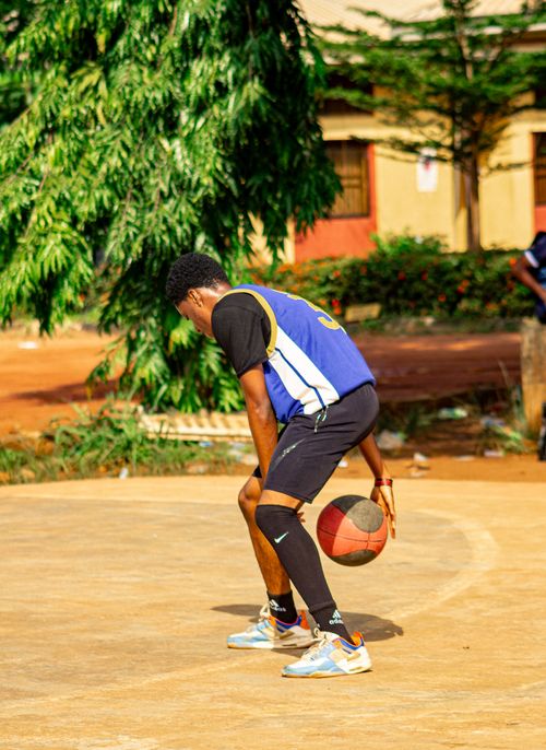 Free A young man playing basketball outdoors on a sunny day. Stock Photo