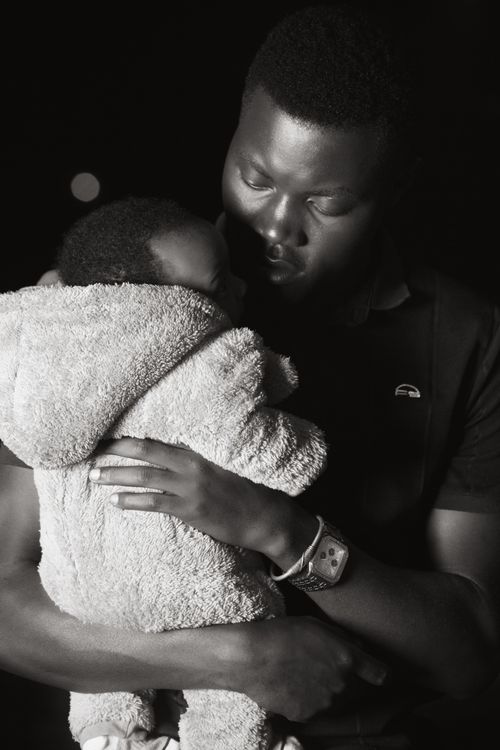 Free Emotive black and white portrait of a father lovingly holding his baby. Stock Photo