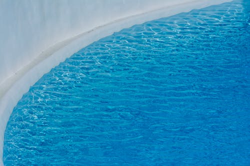 Free Close-up view of peaceful blue swimming pool water with gentle ripples, ideal for relaxation themes. Stock Photo