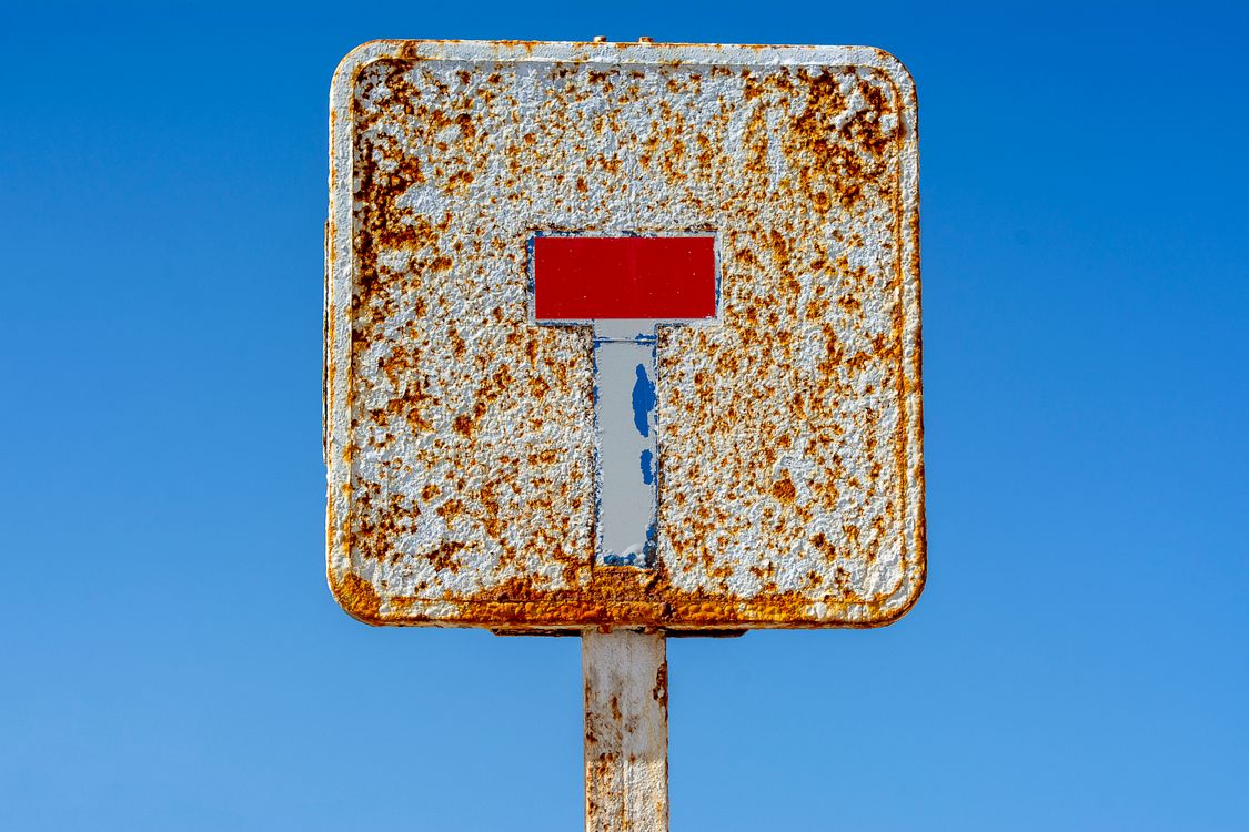 A rusty sign with a red stop sign on it · Free Stock Photo