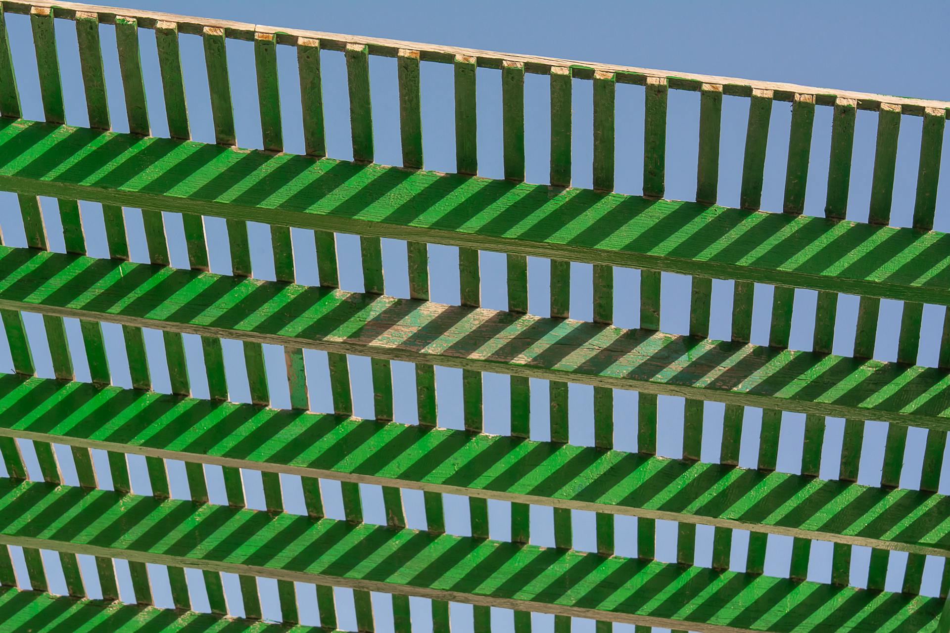 A green and white pergola with green and white stripes