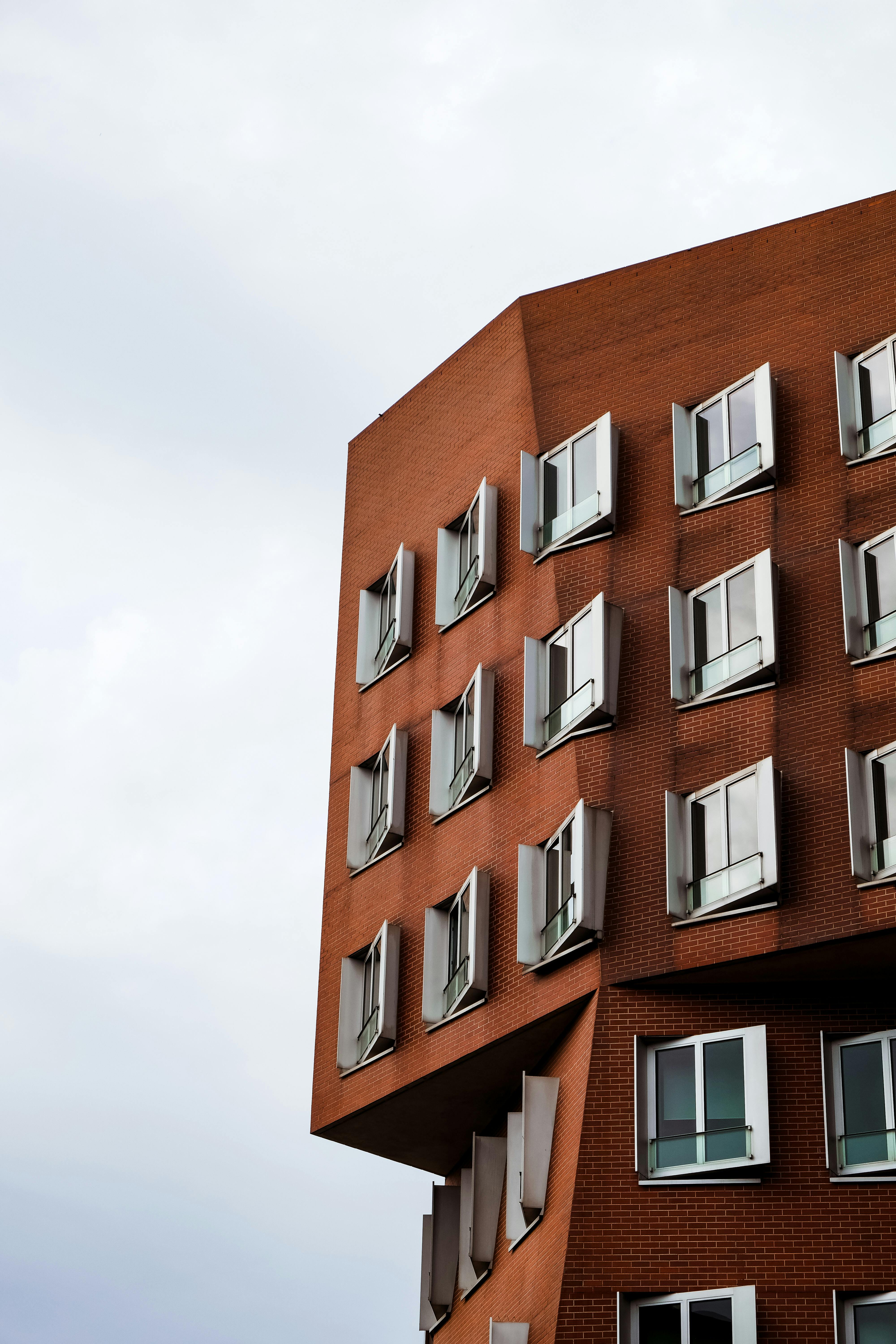 a tall building with windows and a cloudy sky