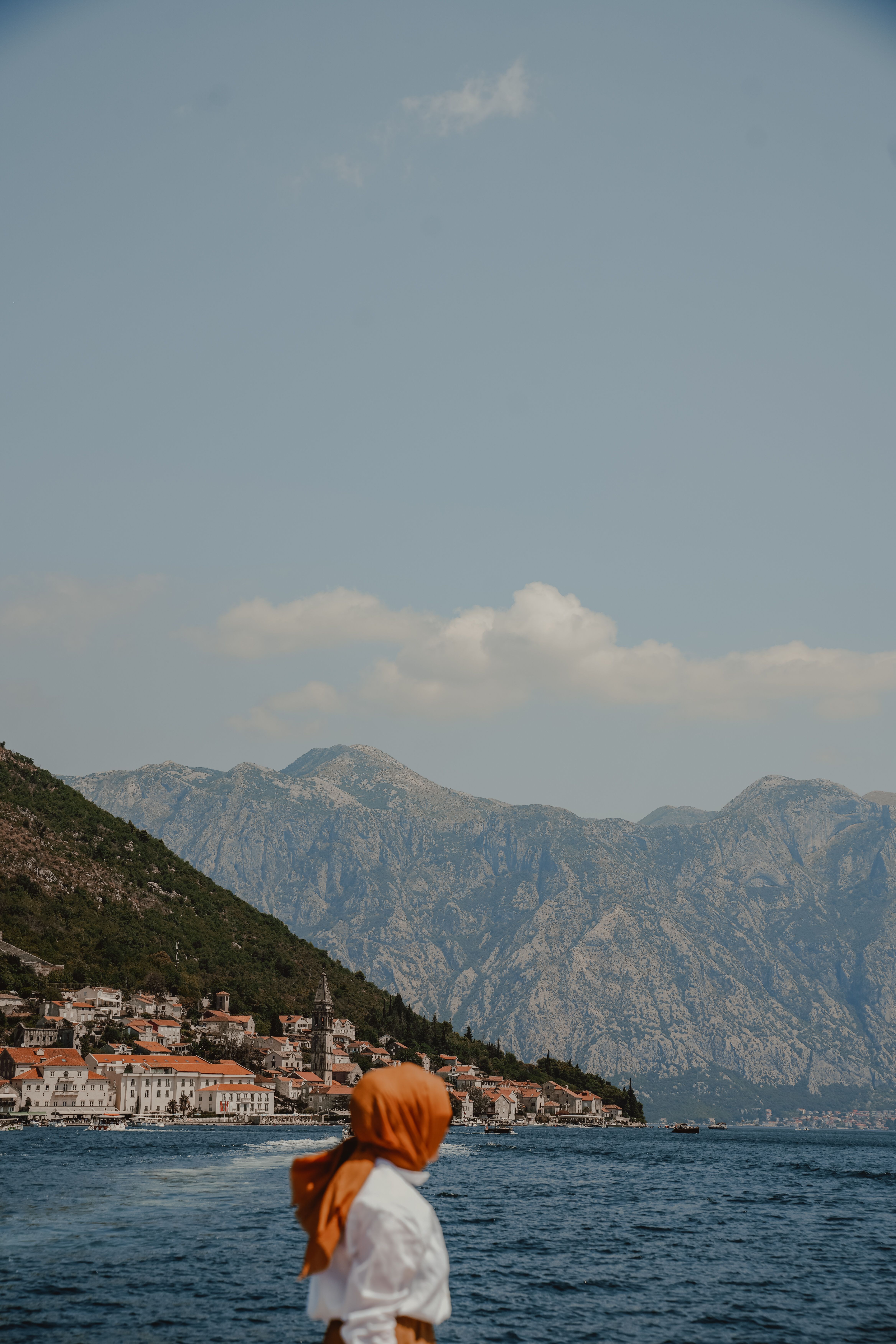 [ColoSach]-a-person-stands-by-the-seaside,-overlooking-the-picturesque-mountains-of-kotor-bay.