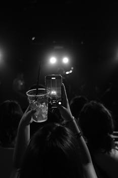 Black and white image of concertgoers capturing a live performance at a nightclub.