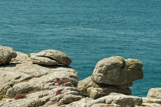 A person standing on a rock near the ocean