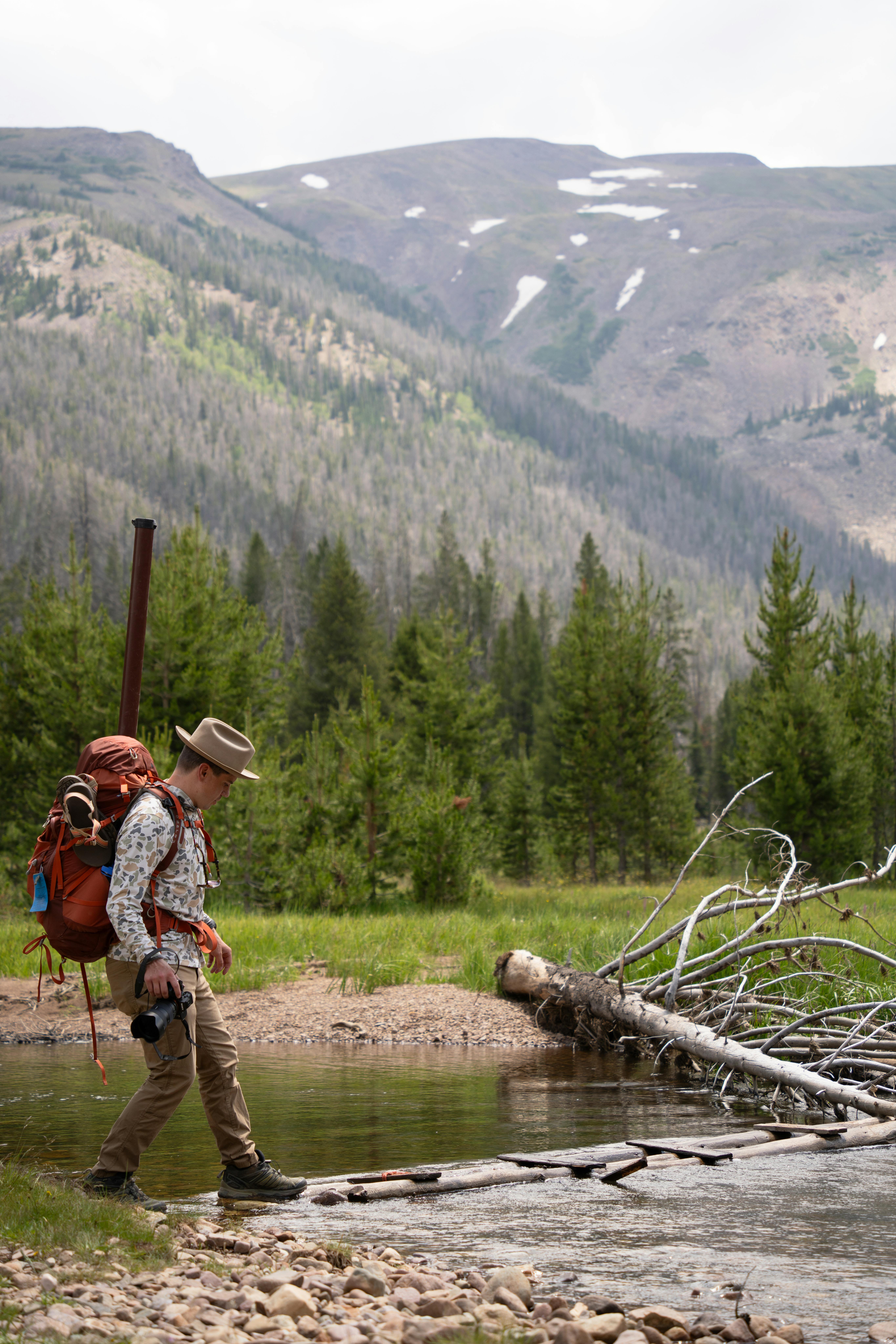 Fotografo che testa una tracolla e un'imbracatura ad accesso rapido in un campo