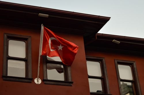 Free The Turkish flag waves proudly on an urban building with traditional architecture. Stock Photo