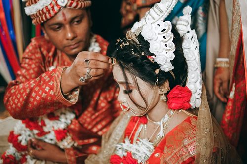 Free A bride and groom perform a sacred ritual during a traditional Indian wedding ceremony with vibrant attire. Stock Photo