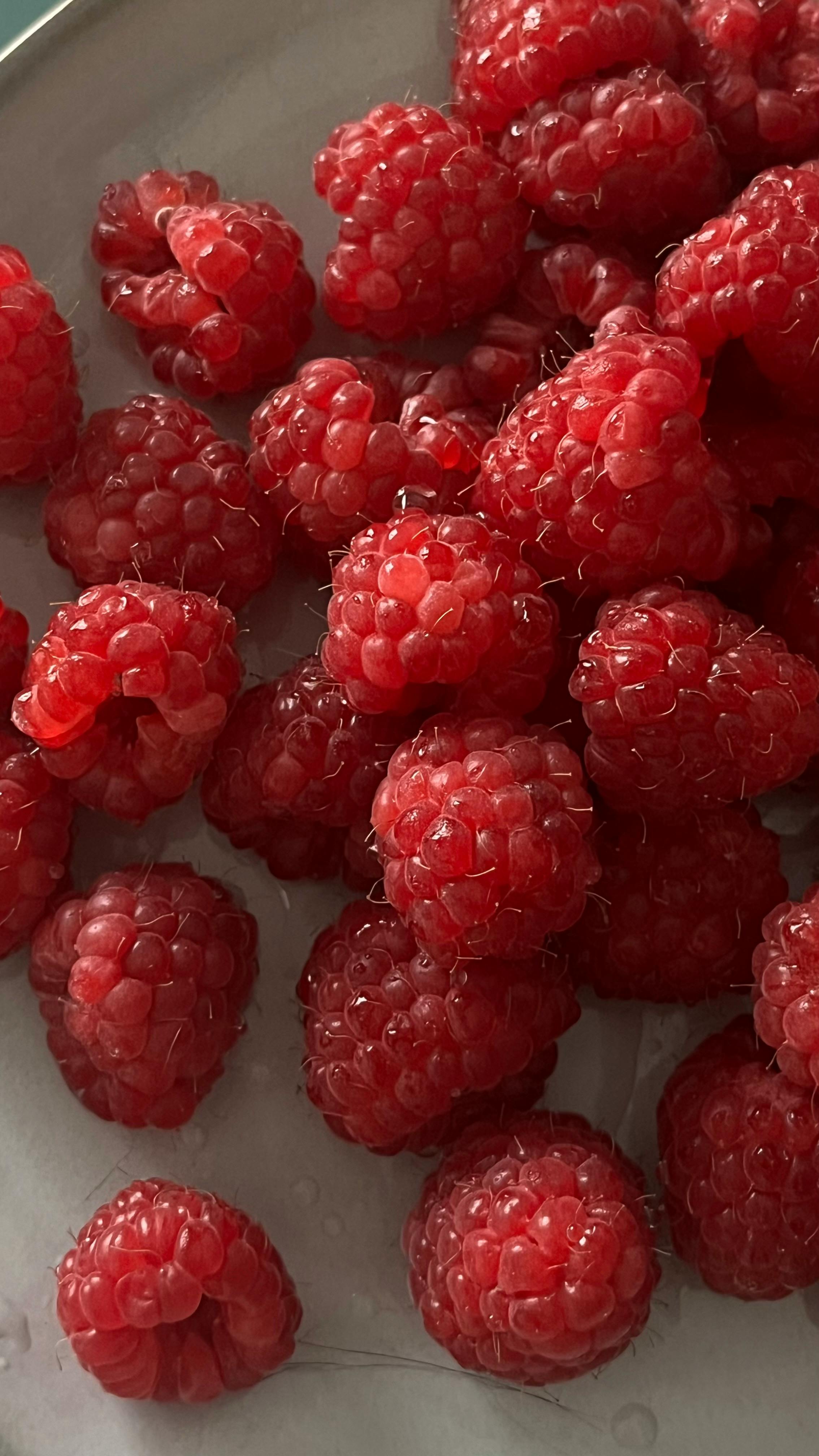 a close up of a plate of raspberries