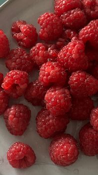 A batch of fresh, juicy raspberries on a plate. Perfect for healthy eating.