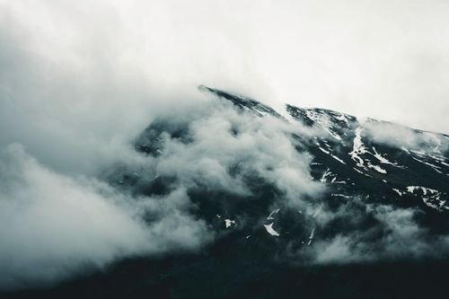 Free Moody clouds envelop the rugged mountain peaks in Banff, creating a mysterious atmosphere. Stock Photo