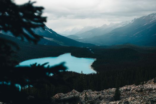 A breathtaking view of a blue lake surrounded by forest and mountains in Banff National Park.