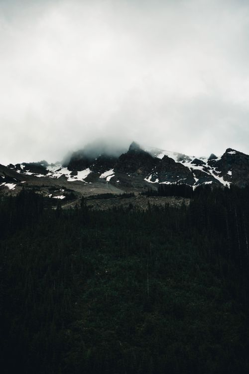 Free Moody mountain landscape in Banff, Canada with fog and snow-capped peaks. Stock Photo