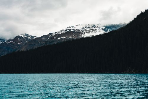 Free Serene view of a mountain lake with snow-capped peaks in Banff National Park. Stock Photo