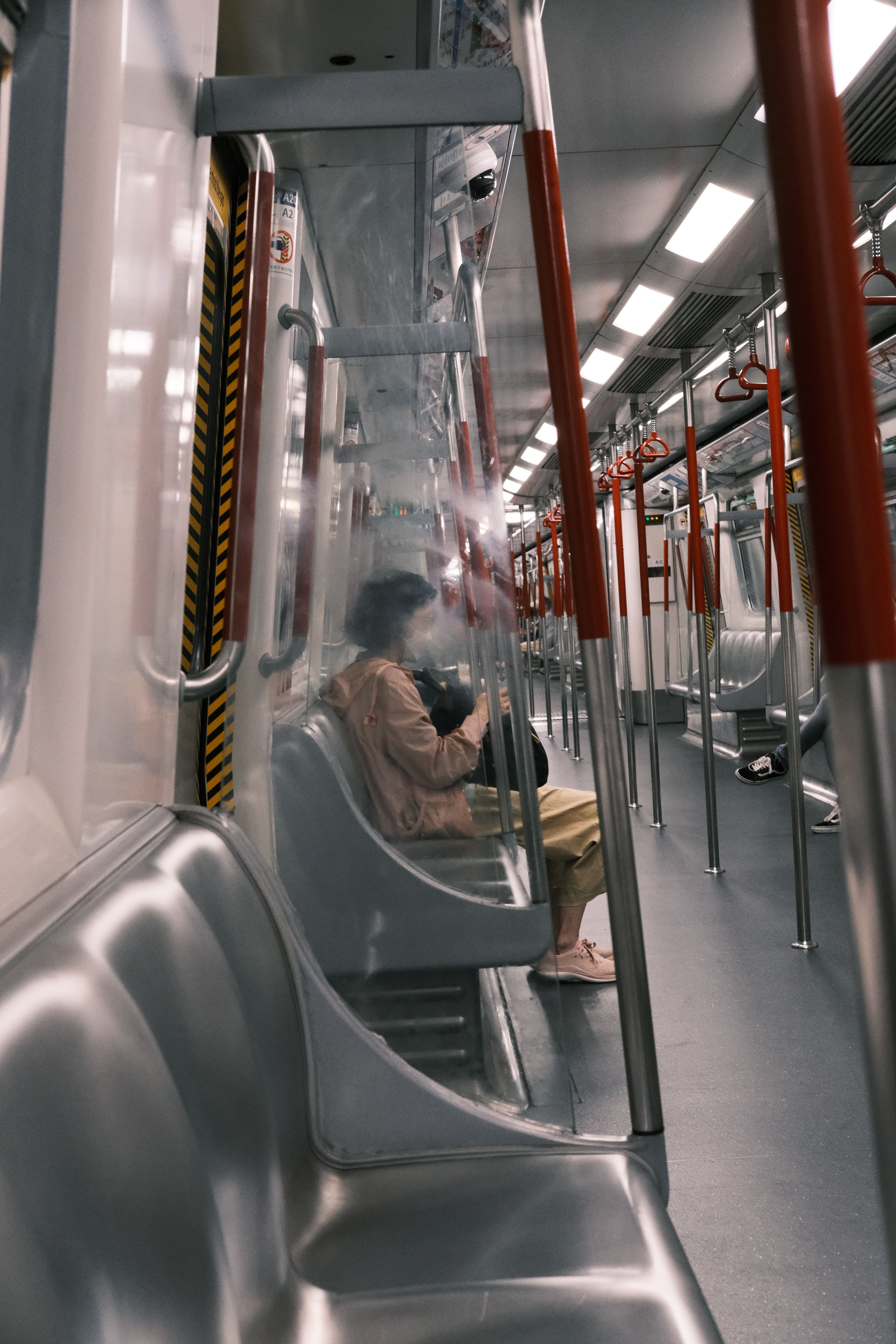 A lone passenger sits inside an empty subway car, capturing an urban travel experience.