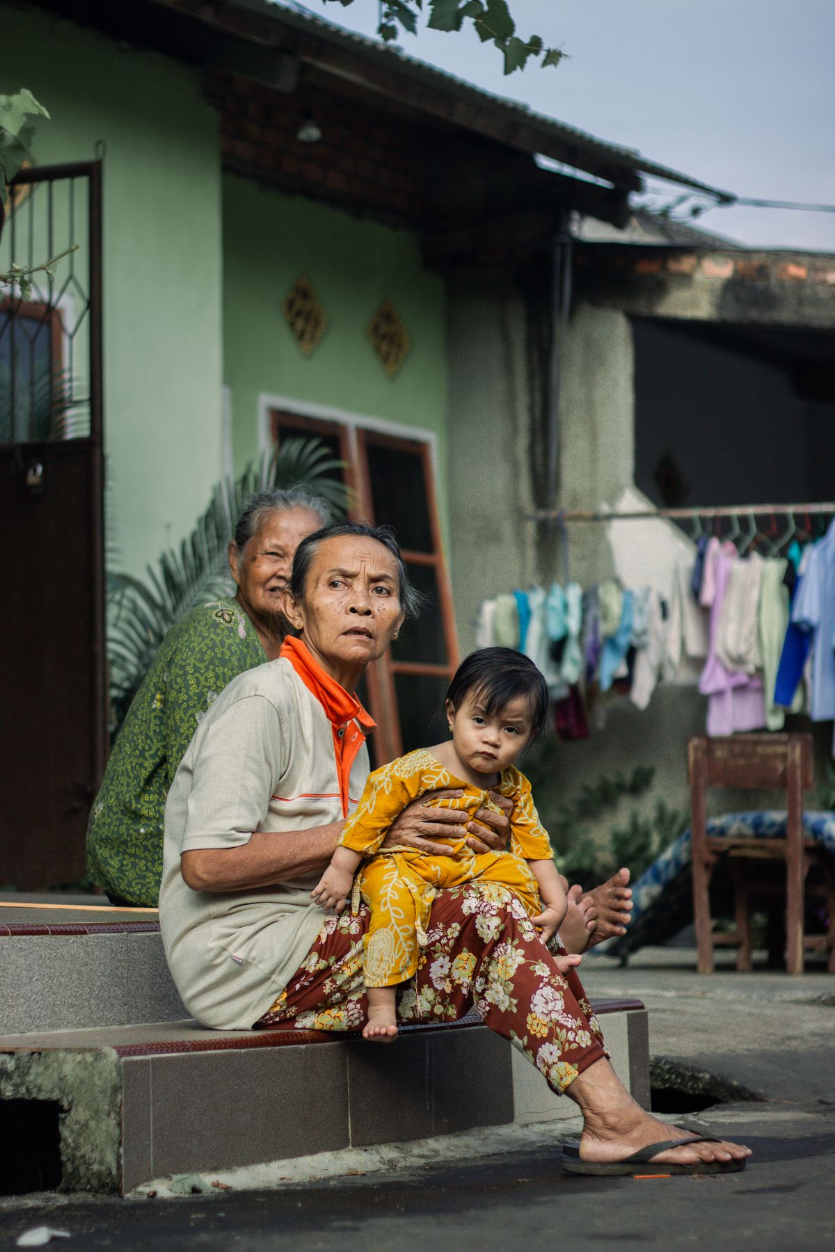Family outside their home in a regional Southeast Asian town, the kind of address East Malaysian deliveries reach