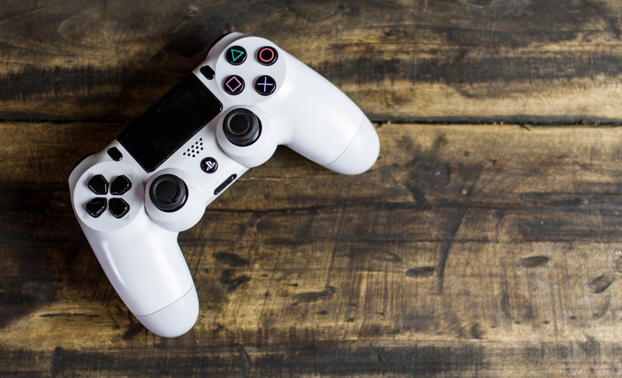 White Gaming Console on Wooden Surface